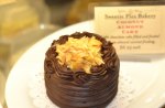 Small  chocolate cake with yellow stuff on top.