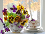 Tea and pansies at window