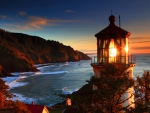 glowing lighthouse on a red oregon sea coast