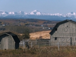 Farm houses and Rocky mountains on the back
