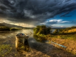 dark clouds over boat on a river hdr