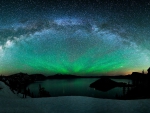 aurora borealis and the milky way above a lake