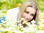 Beautiful girl laying on the daisy flowers field