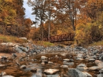 Small wooden bridge above a rocky stream
