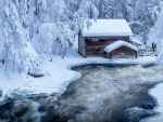 Snowy Log Cabin at Kitkajoki River in Finland