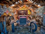Old vehicle in a garage filled with signs from around the Eastern Sierra, Bishop, CA