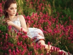 Model Among Field of Red Flowers
