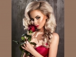 Blonde smelling a red rose