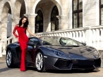 model in long red dress with her Ferrari