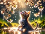 A kitten marvels at sparkling water droplets under a sunlit branch with blossoming flowers.