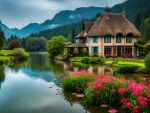 The house is surrounded by flowers and a river